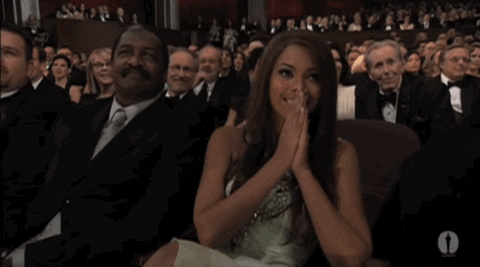Celebrity gif. Beyonce is at the Oscars and she has prayer hands up to her face as she watches the stage intently.