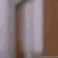 Movie gif. A doorway slowly comes into focus. A man in a white jacket, chewing something, leans out for a thumbs up.