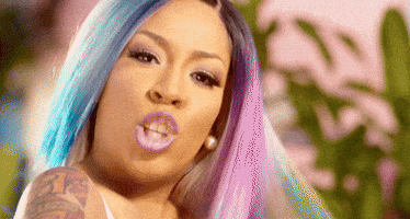 Celebrity gif. K Michelle looks at us with a serious expression and points directly at us.