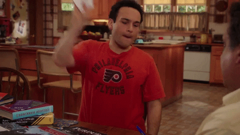 TV gif. Troy Gentile as Barry in the Goldbergs slams a piece of paper down on the table in front of him as if to say, "read it and weep."