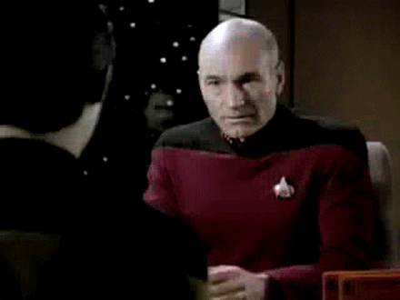 TV gif. Patrick Stewart as Picard in "Star Trek" looks aghast and then leans forward to put his head in his hands.