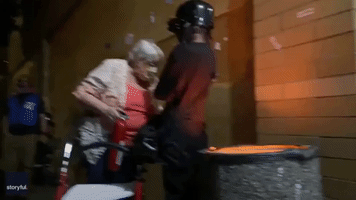 Elderly Woman Displays BLM Sign as She Extinguishes Fire Guarded by Portland Protester