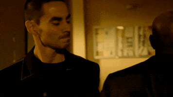 TV gif. Morris Chestnut playing Dr. Beaumont Rosewood Jr. in Rosewood gets into a punching fight with another man in a dimly lit building. Chestnut lands a punch before his opponent retaliates and socks him in the face.
