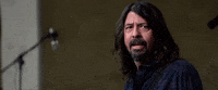 Celebrity gif. Dave Grohl sees something and turns away while rolling his eyes heavily.
