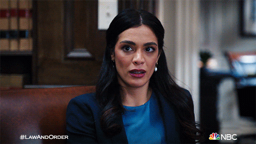 TV gif. Law & Order characters Jack McCoy, Samantha Maroun, and Nolan Price exchange knowing looks.