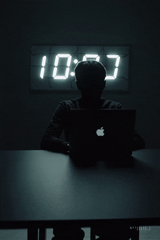 Person working urgently at laptop in dark room
