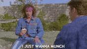 Movie gif. Sitting outside, Pauly Shore as Stoney Brown in Encino Man looks down at his bagel, and tells someone offscreen, "I just wanna munch," which appears as text.