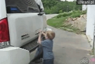 Video gif. A child opens the trunk of an SUV but doesn't let go of the handle and he slowly gets lifted up as the trunk of the car opens.