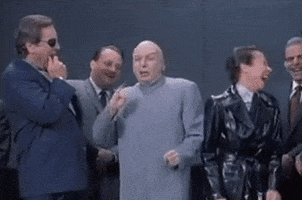 Movie gif. Mike Myers as Doctor Evil in Austin Powers stands with a bunch of other evil people and they all laugh like they’re making fun of or mocking someone else.