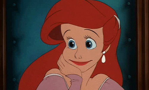Disney gif. Ariel from "The Little Mermaid" wears a poofy pink dress and sits at a table with her head in her hand, nodding and smiling eagerly.