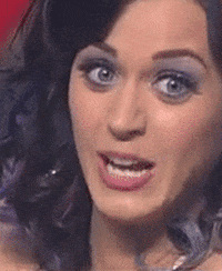 Celebrity gif. Katy Perry looks at us with wide eyes and seems to be saying "ooo!" in response to some juicy info.