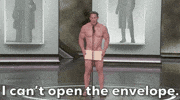 Oscars 2024 GIF. A naked John Cena has finally made it to the microphone with the Oscars envelope covering his privates. He looks frightened as he has a sudden realization that the winner is in the envelope. The envelope that holds his dignity together. He finally admits to us, "I can't open the envelope." 