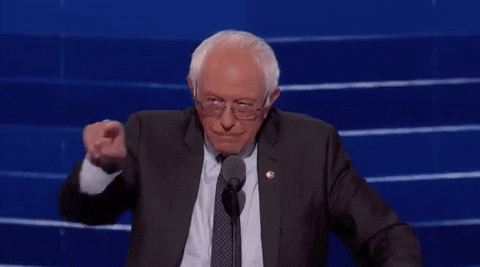 Political gif. Bernie Sanders at the Democratic National Convention leans over a microphone and points out at the crowd. He laughs as he nods his head and then gives a quick thumbs up, laughing harder.