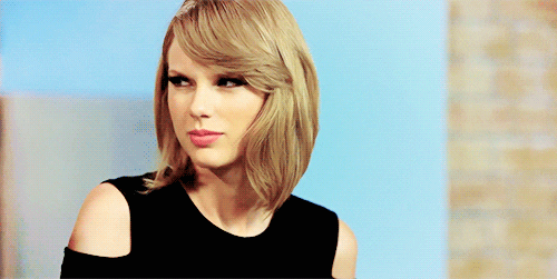 Celebrity gif. Taylor Swift shakes her head and sneers at someone.