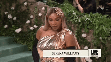 Met Gala 2024 gif. Serena Williams, dressed in gold, poses for the cameras.