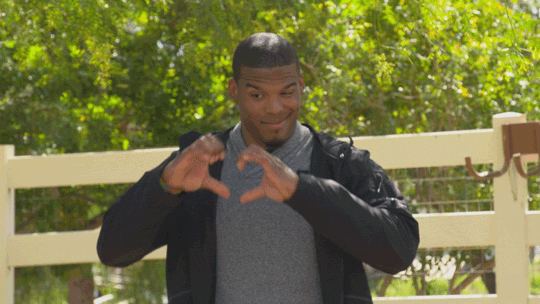Reality TV gif. NFL MVP Cam Newton on All in With Cam Newton holds his hands up into a heart shape. 