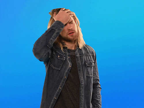 Video gif. Man stands in front of a blue background and has a hand clasped to his forehead. He scrunches his face at us as he facepalms and looks very perplexed.