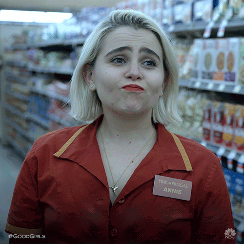 TV gif. Mae Whitman as Annie Marks on Good Girls stands in a grocery store aisle in a work uniform. She looks at someone, nodding with pursed lips, and looks away with a smug look on her face. 