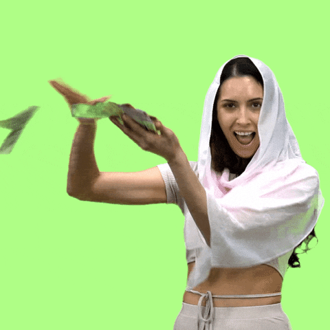 Video gif. Closeup of a woman wearing a white hijab swiping cash off a pile in her hand as she looks at us with a gaping smile. Bills rain down beside her in front of a lime green background.
