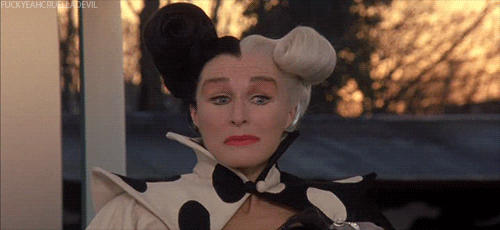 Disney gif. Glenn Close as Cruella de Vil in 101 Dalmations opens her eyes wide and says, “oops.”