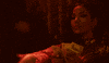 Music video gif. In a darkly-lit room, Jhene Aiko counts some money.