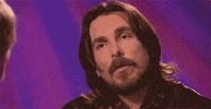 Celebrity gif. Christian Bale spaces out in an interview before furrowing his eyebrows in confusion.