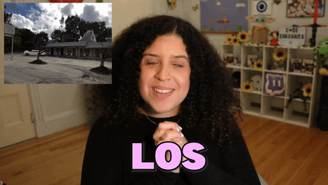 Video gif. Shalymar Rivera Gonzalez smiles at us with her hands clasped together. A short video of a house exterior plays in the corner. She says, "Los amusement parks," which appears as text. 