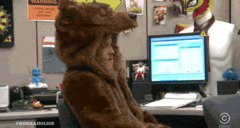 TV gif. Blake Anderson as Blake in Workaholics. He's sitting at his cubicle but is dressed in a full bear costume, complete with the bear head. He spins around in his chair and sassily says, "Fur Sure."