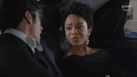 TV gif. Rachel Hilson as Nora in "Red, White and Royal Blue" sits in the back of a car, looking over at Alex Ozerov as Malcolm with concern. Text, "Are you crazy?'