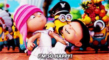 Despicable Me gif. Agnes and Edith in Despicable Me 2 wear white dresses. Agnes pulls on the collar of Edith’s dress and shakes her as she screams out, “I'm So Happy! A crowd of minions dressed in different costumes dance and sing behind them. 