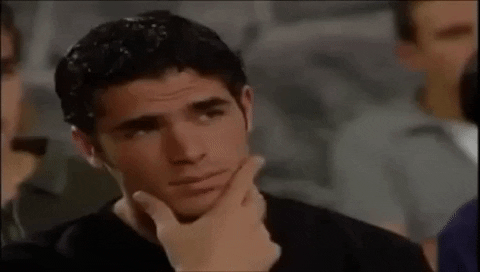 TV gif. Handsome man furrows his dark eyebrows and scratches his chin while gazing at something in contemplation.