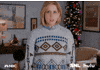 SNL gif. Vanessa Bayer stands in a living room decorated for Christmas looking straight ahead, breathing heavily. She grits her teeth as the shot cuts closer into her face. Suddenly flames erupt around her and in her eyes expressing rage.