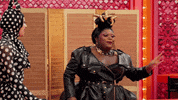 Reality TV gif. Kornbread from RuPaul's Drag Race looks at something and looks back at us with wide eyes and a scrunched nose, pushing imaginary hair away from their face as they're shocked and slightly disgusted at what they've seen.