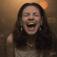TV gif. Mila Kunis as Jackie in That Seventies Show throws herself forward and backward as she laughs hysterically. 