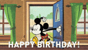 Disney gif. Mickey Mouse opens his front door into his house, whistling with his eyes closed. He opens his eyes and sees a surprise party with all his friends cheering for  him. Balloons float around the ceiling and confetti falls around them. Text, “Happy Birthday!”