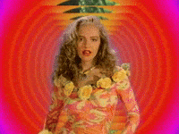 Video gif. A retro edit of a young woman wearing a floral dress who points at us and says, "You." The background warps in on her, adding a dramatic effect.