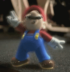 Cartoon gif. Mario is rocking out hard, with two hands spread apart in the rock on symbol and the peace sign. His eyes are closed and his legs shake in unison with his head, which is head banging.