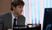 The Office gif. John Krasinski as Jim sits at a desk in a different office looking at his screen nervously, finally looking at us slowly, and very slightly shakes his head, trying not to be noticed. 