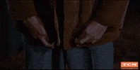 Movie gif. Sal Mineo as Plato in Rebel Without a Cause raises two crossed fingers to his chest as he nodes his head as if offering the best of luck. 