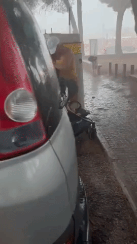 Family Shelters Behind Car During Mallorca Storm