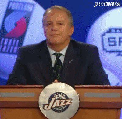 Sports gif. Man standing at the Utah Jazz podium reacts to something with surprise and says with a smile, “Damn.”