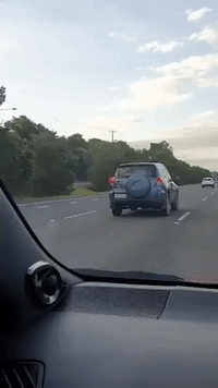 Cyclist Hitches a Ride by Holding Onto Trailer on Queensland Highway