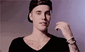 Celebrity gif. Justin Bieber looks up innocently and shrugs, looking at someone with an unsure smirk.