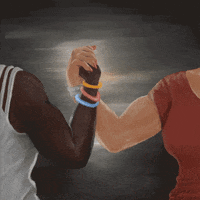 Digital art gif. Two women clasp their hands together, flexing their muscles against a gray-painted background. Text, “We are the solution.”
