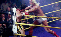 Movie gif. Hulk Hogan as Thunderlips and Sylvester Stallone as Rocky in Rocky III. Thunderlips has Rocky in the corner of the ring and he gives Rocky a huge knee to the gut, making Rocky bend over in pain.