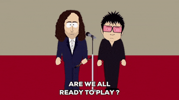 South Park gif. Yoko Ono side eyes Kenny G as he speaks into a microphone, saying, "Are we all ready to play? Thanks. Let's see the music."