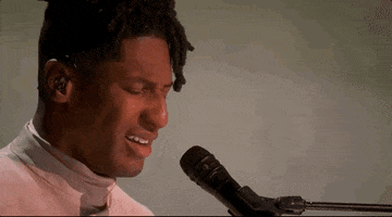 Oscars 2024 GIF. Close up shot of Jon Batiste performing "Never Went Away" from American Symphony. His brow furrows with concentration and he closes his eyes as he sings.