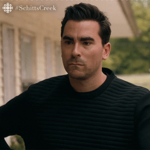 Schitt’s Creek gif. Dan Levy as David Rose stands with his hands on his hips, biting his lips and shaking his head. He says, “I want that,” and cringes as if holding in his sadness. 