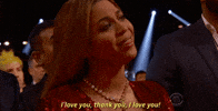Celebrity gif. Beyonce at the Grammys is seated in the audience and looks wistfully towards the stage, tears in her eyes, as she shakes her head slowly and says, "I love you. Thank you. I love you!"