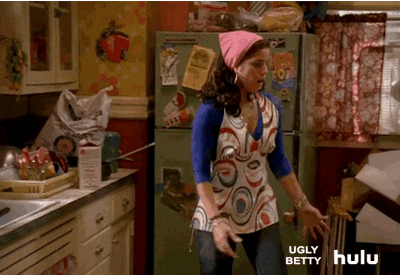 GIF de mulher com avental e touca, na cozinha, correndo para abrir o forno que está cheio de fumaça.